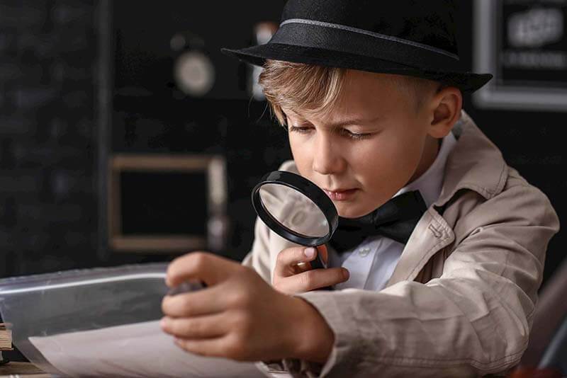Student using a magnifying glass to read historical document