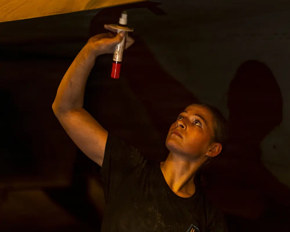 Photo of a member of the USS Abraham Lincoln crew doing repairs.