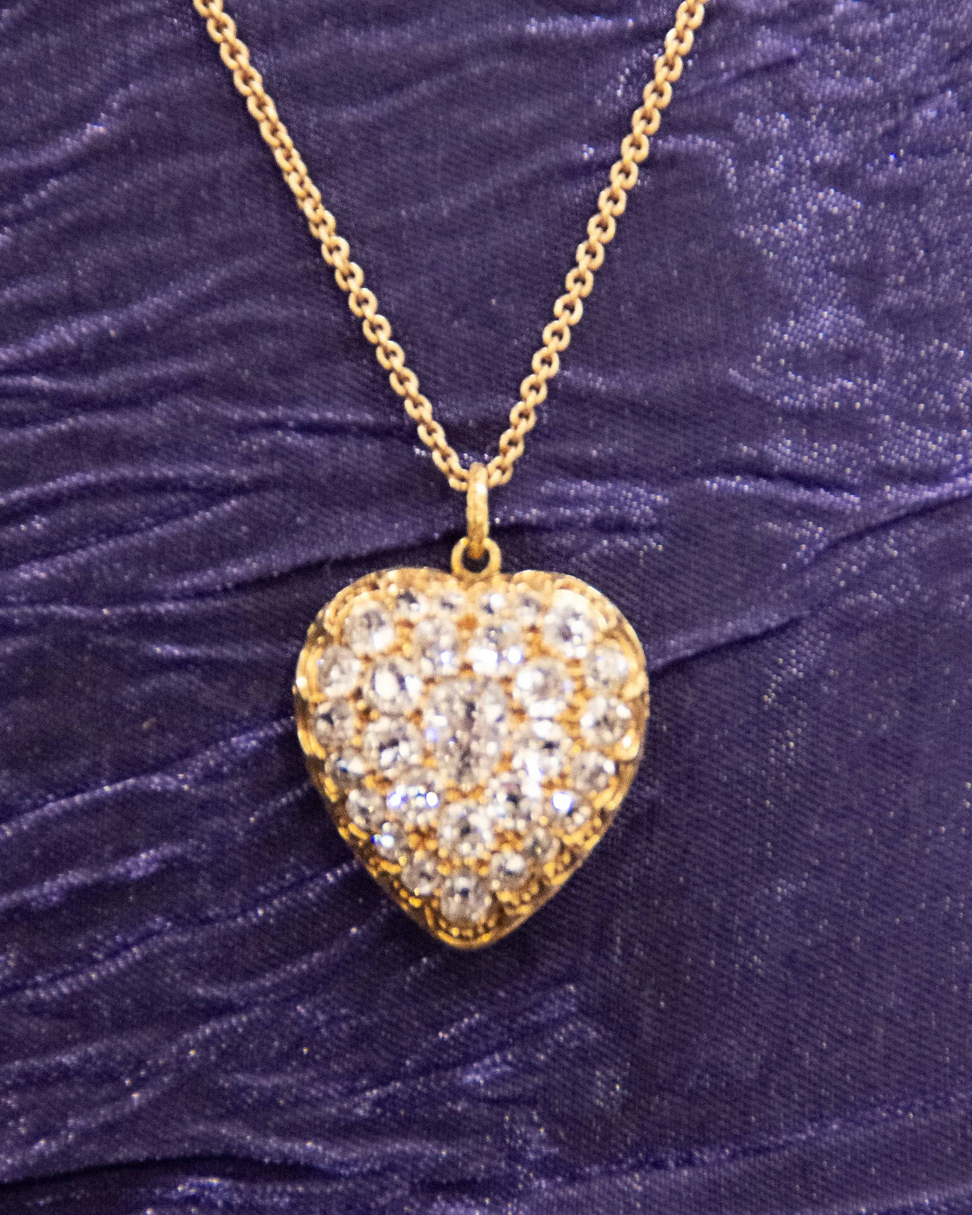 Photo of a necklace with a heart-shaped locket covered in diamonds.