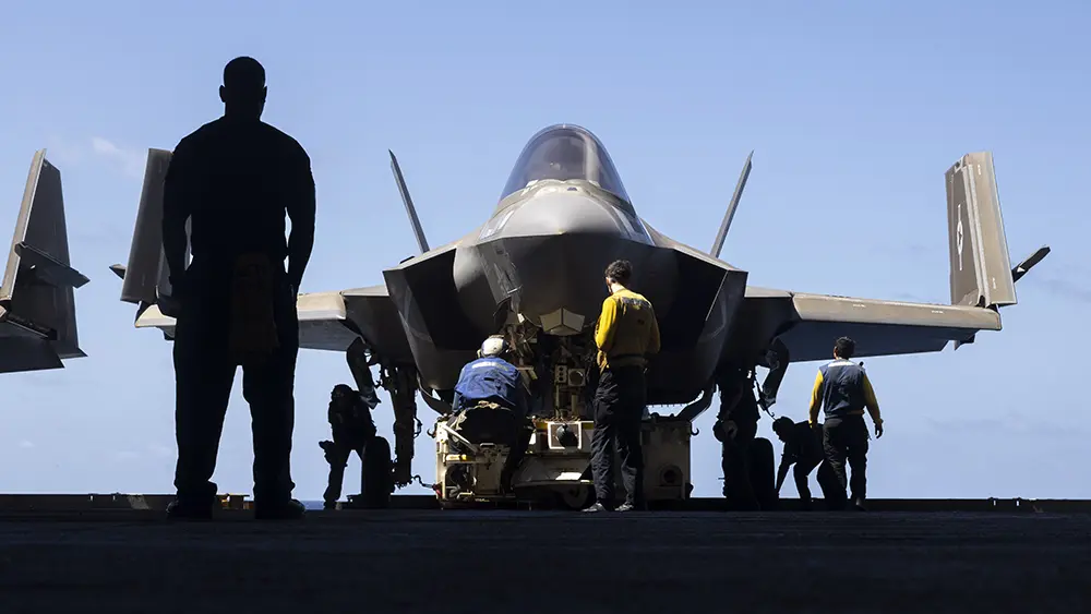 Photo of military personnel working on a jet plane