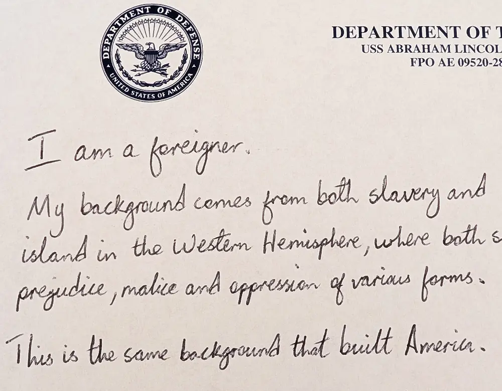 Detail from a photo of a handwritten essay. The top line says, "I am a foreigner."